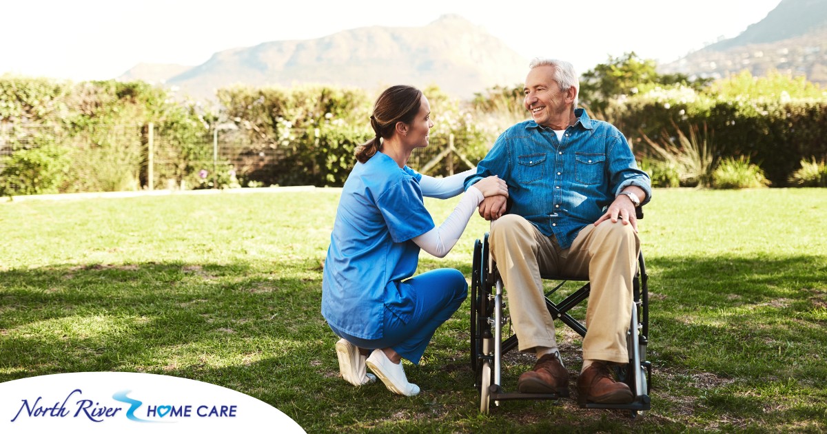 Caregivers like this one talking to a smiling senior patiently and compassionately help clients and help them with aging in place while dealing with different conditions.