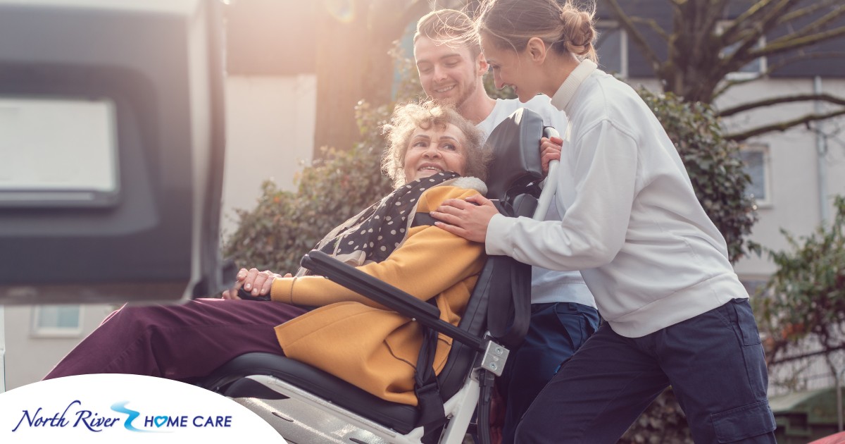 2 caregivers help an older adult get into a vehicle using a ramp, showing how equipment is valuable to professional caregivers when helping older adults.