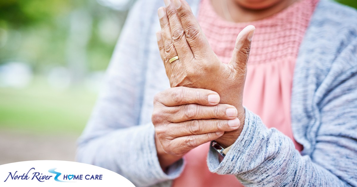 A senior woman holds her hand in pain, representing arthritis and what Arthritis Awareness Month can help with.