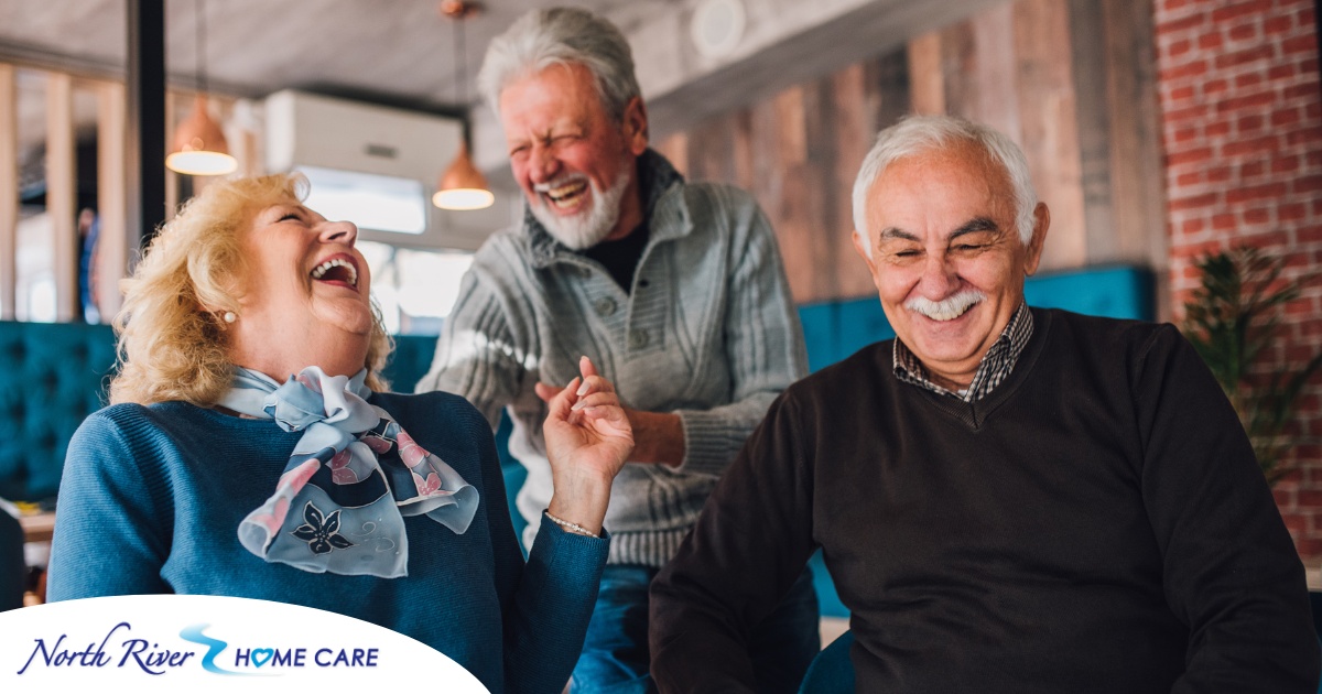 Older adults laugh and enjoy each other’s company representing how socialization can help seniors.