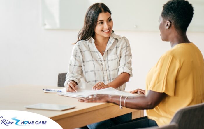 A woman happily interviews another woman, representing how well caregiver interviews can go when prepared.