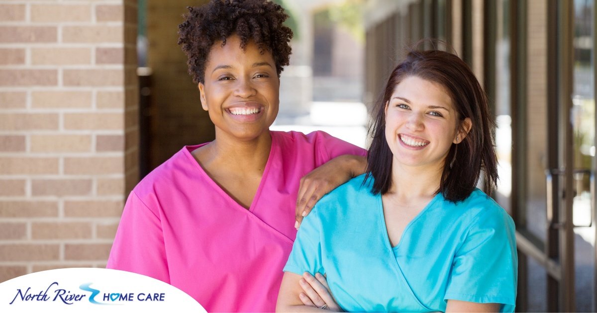 2 caregivers smile representing the good attitude that can allow home care professionals to collaborate.