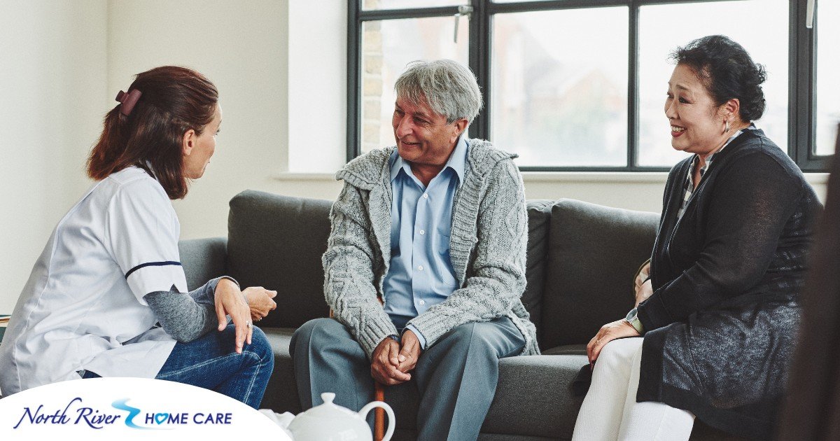 A caregiver talks with an elderly couple representing the kind of communication that professional caregivers need to have to anticipate client needs.