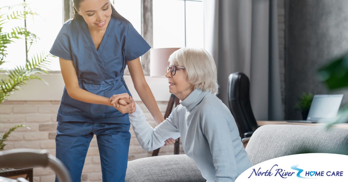 A caregiver demonstrates her caregiver skills by helping an older adult get up.