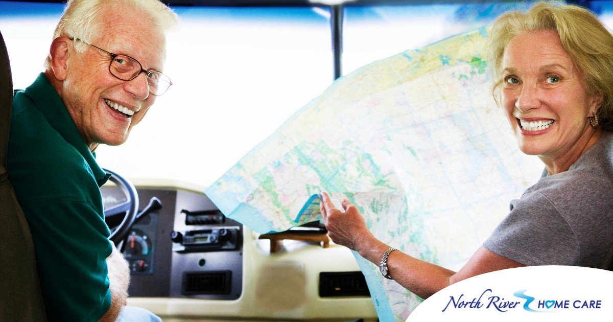 An older couple looks back smiling from the front of an RV, representing how day trips for seniors can help boost the mood of everyone.