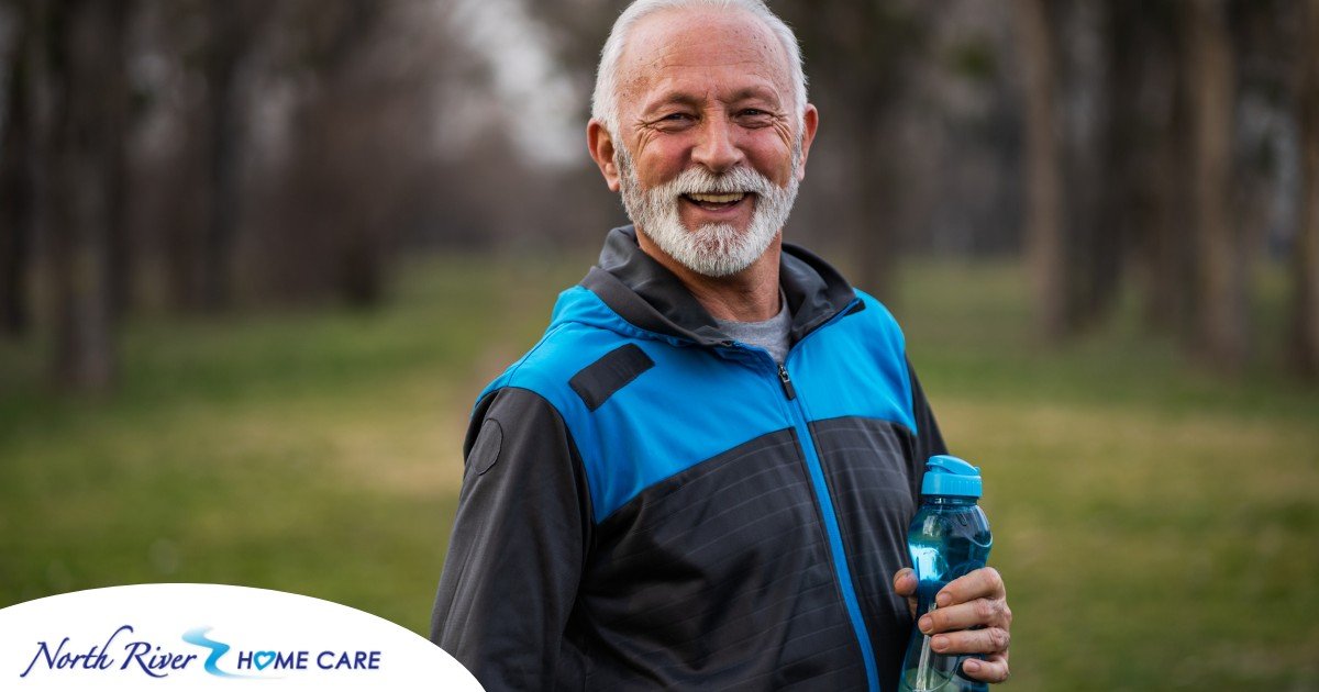 An older man smiles with a water bottle while exercising, representing the benefits of encouraging exercise when caring for seniors at home.