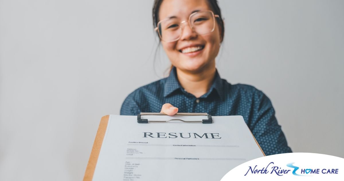 A woman happily hands in a resume, representing a successfully written caregiver resume.