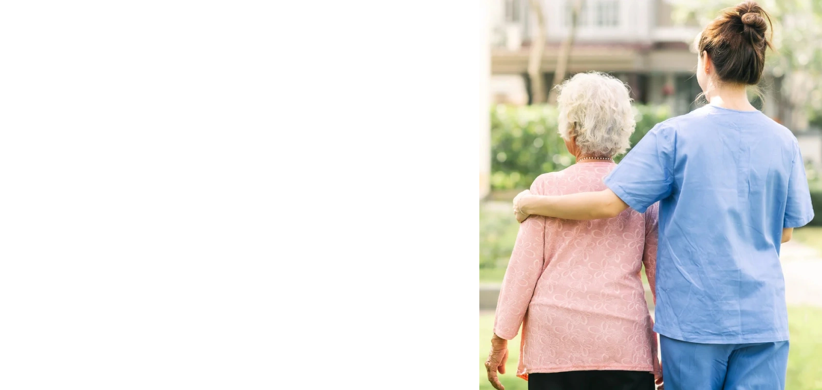 A caregiver walking arm in arm with an older woman