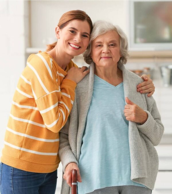 A smiling woman with her arm around her mother at home